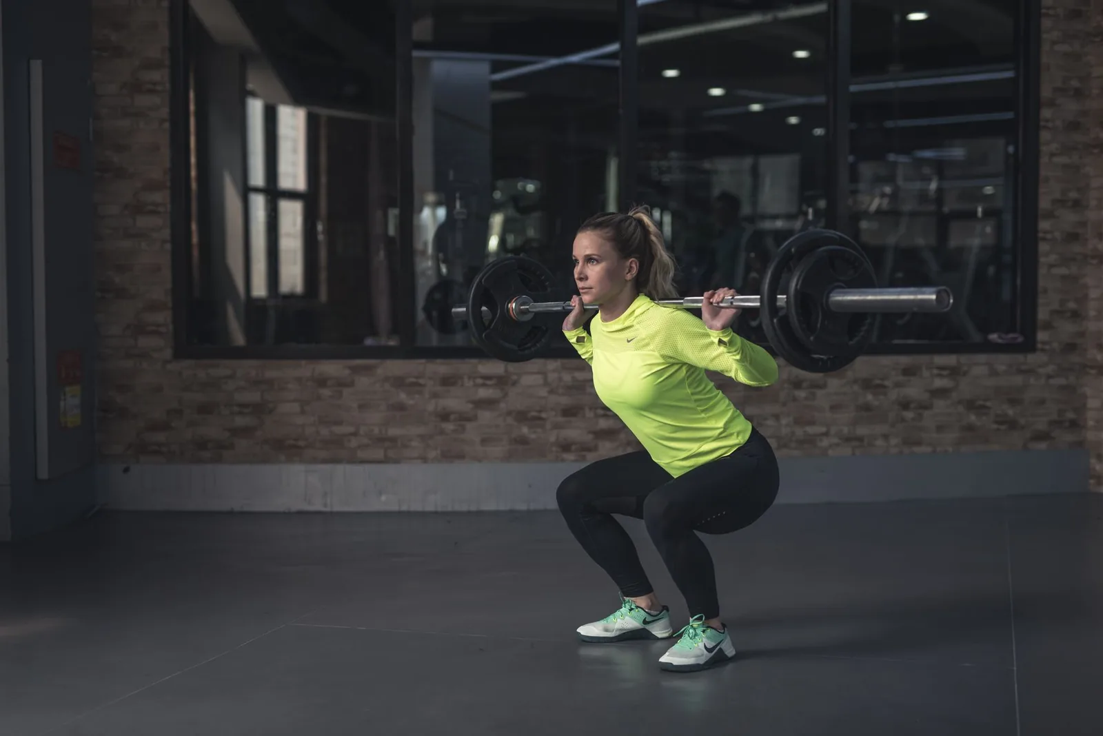 Atleta levantando barra en el gimnasio construyendo su marca personal