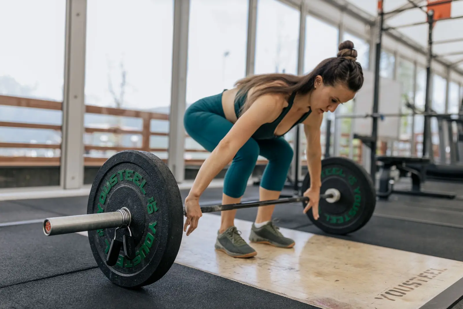 Mujer entrenando fuerza con barra en gimnasio