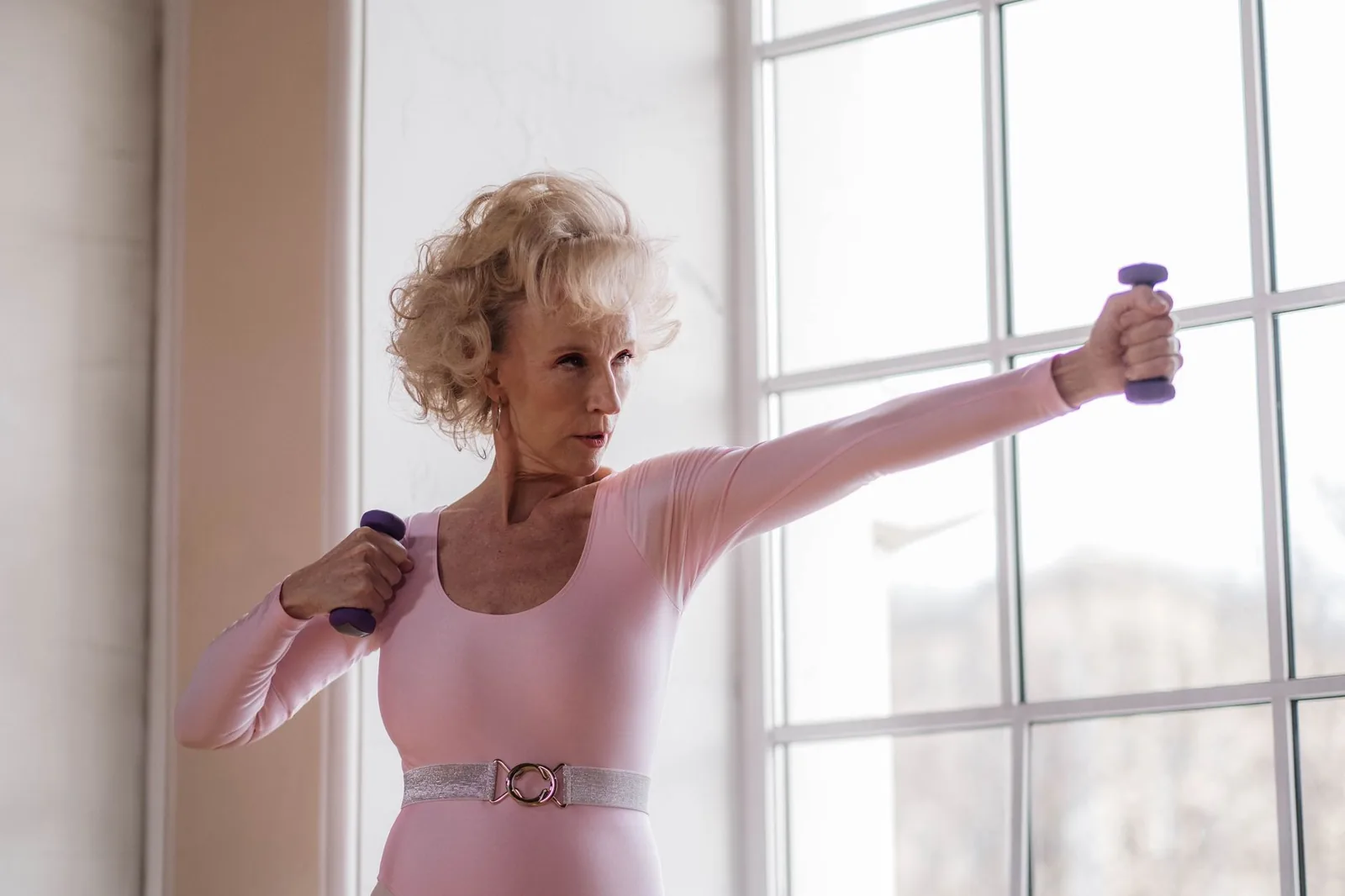 Mujer madura entrenando fuerza con mancuernas