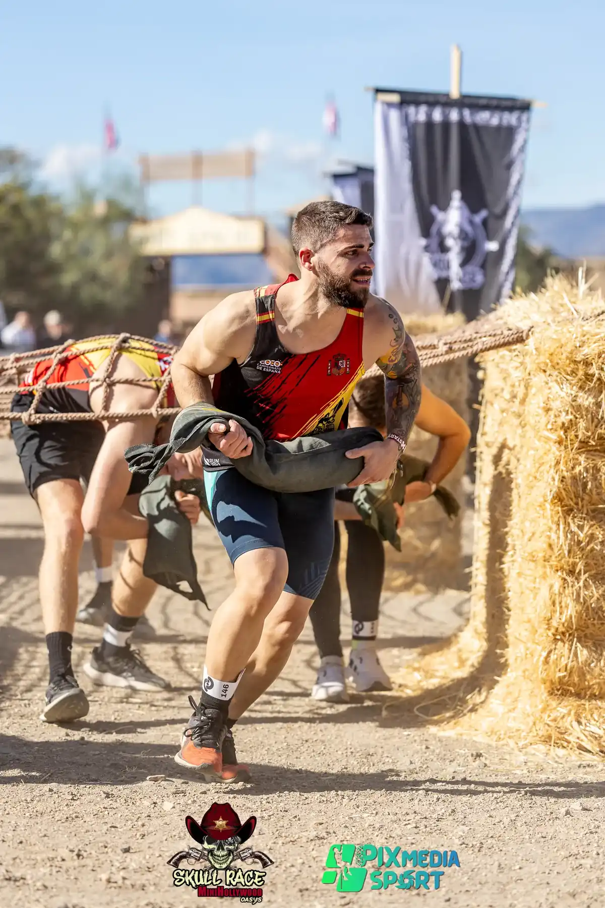 Participante cargando sacos de arena en un obstáculo de carga de una carrera OCR