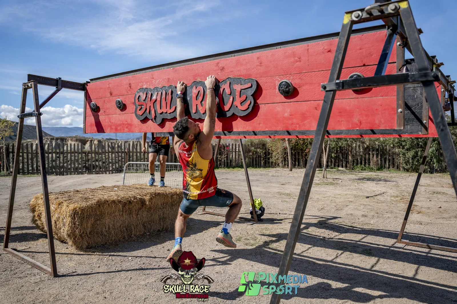 Participantes superando la lona negra con el logo de Skull Race en una carrera de obstáculos