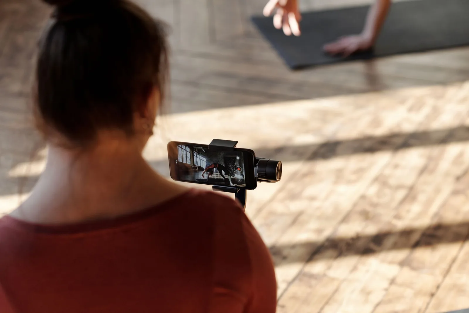 Cuánto Cobrar como Microinfluencer Fitness en 2026: Tarifas por Seguidores 1 Creadora grabando un vídeo de entrenamiento en el gimnasio con el móvil
